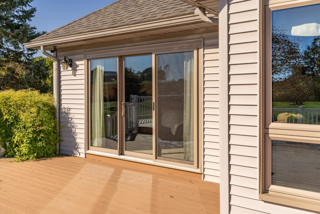 ProVia Aeris three-panel sliding patio door in a Chateau finish opening onto a deck